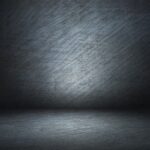 Dark gray textured background with scratched metal surface and spotlight effect, like a stage or studio backdrop