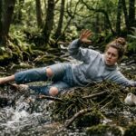 a woman trying to walk down a mountain but is falling and can't catch herself